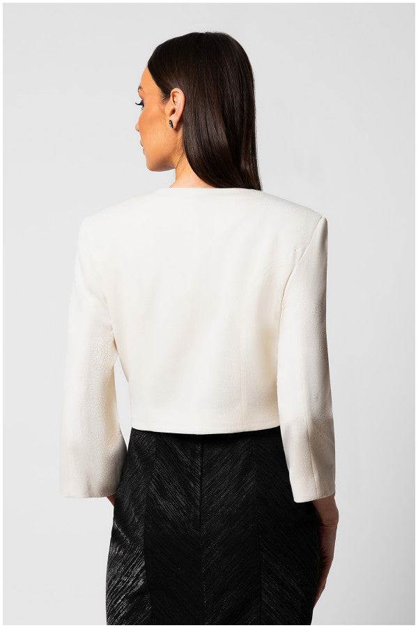 Woman wearing a white tailored blazer jacket with structured shoulders and a round neckline, viewed from the back.