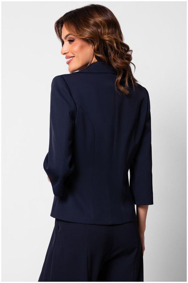 Woman wearing a navy tailored blazer Alexa blazer with a fitted silhouette and three-quarter sleeves, shown from the back.