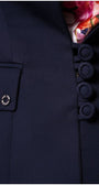Close-up of navy tailored blazer Alexa blazer showing fabric texture, covered buttons, and floral inner lining detail by the pocket.