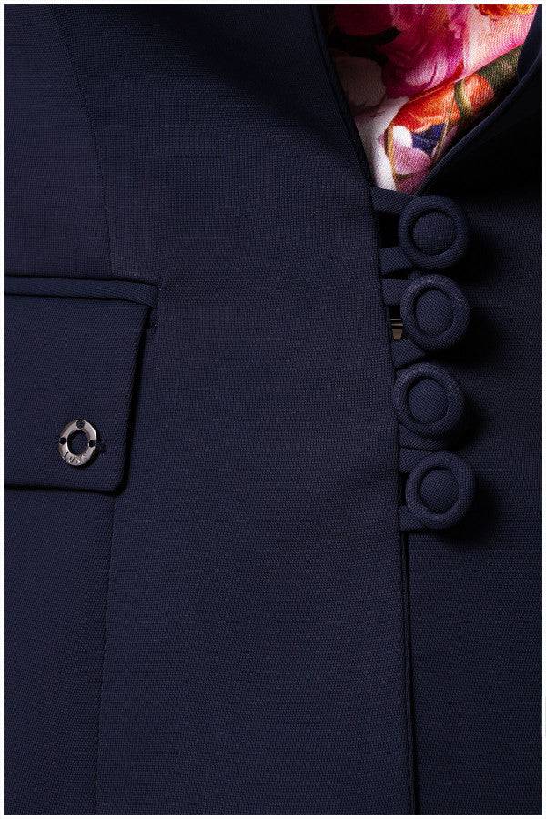 Close-up of navy tailored blazer Alexa blazer showing fabric texture, covered buttons, and floral inner lining detail by the pocket.