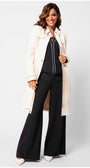 Woman wearing a beige trench coat over a black outfit on a white background Luna Fashion House