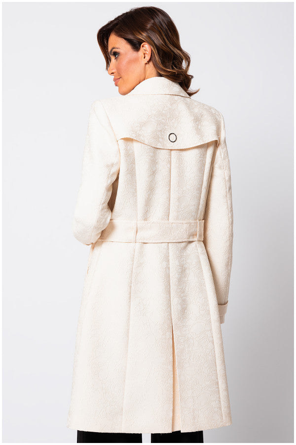 Close-up of beige jacquard trench coat fabric showing subtle textured detail. Luna Fashion House