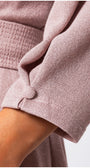Close-up of a person wearing a pink textured garment with a blurred background Luna Fashion House