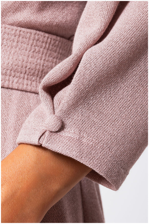 Close-up of a person wearing a pink textured garment with a blurred background Luna Fashion House