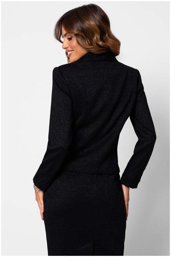 The back view of a black lace tailored blazer detailing on cuffs and textured fabric