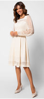 Woman wearing a white dress with sheer sleeves on a white background Luna Fashion House
