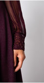 Close-up of a dark purple garment with lace cuffs on a plain background Luna Fashion House