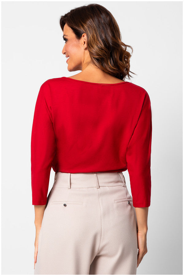 Woman wearing a red top and beige pants on a white background  Luna Fashion House