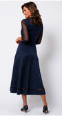 Woman wearing a navy blue dress with sheer sleeves on a white background Luna Fashion House