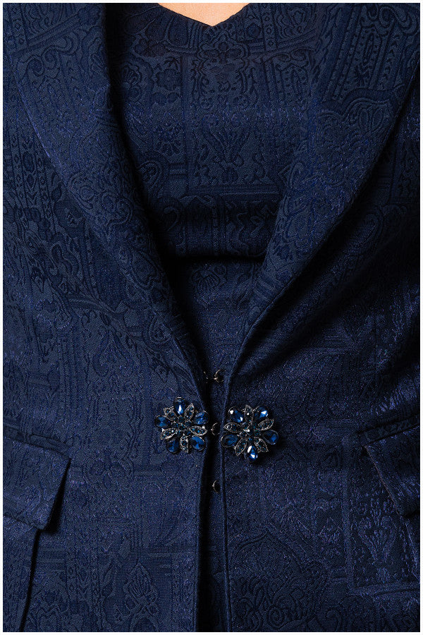 Navy blue patterned coat with decorative buttons on a plain background