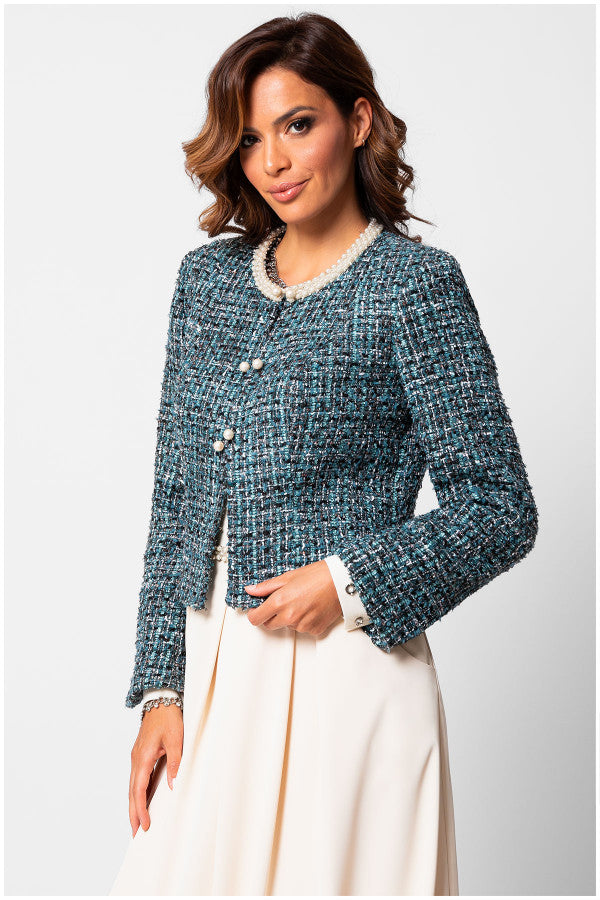 Woman wearing a blue tweed Luna Fashion House jacket with white trim on a light gray background