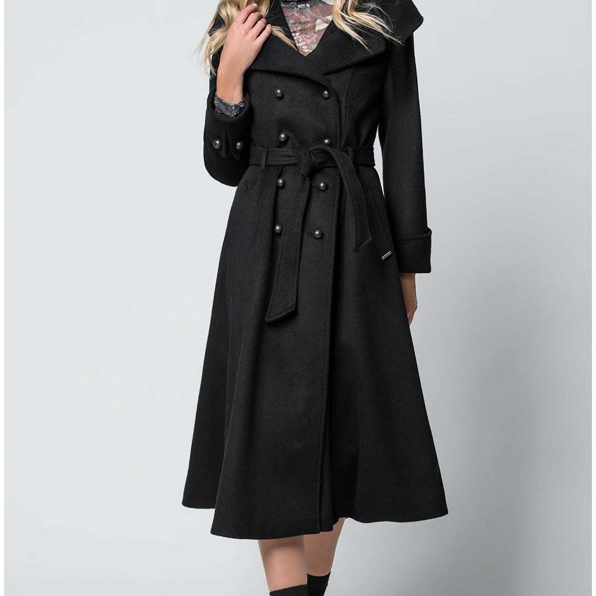 Woman wearing a black Luna Fashion House coat on a white background