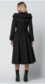 Woman wearing a black Luna Fashion House coat from behind on a light gray background