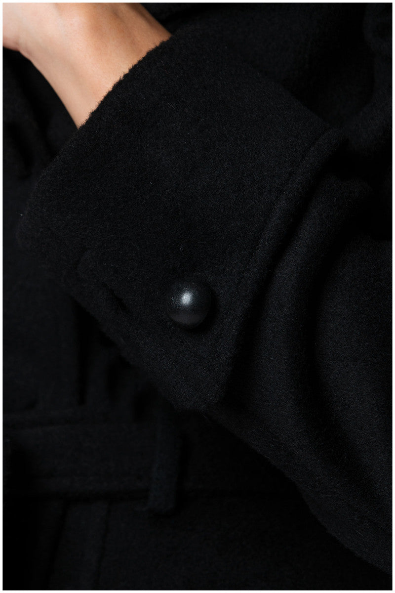 Close-up of a black Luna Fashion House coat with a button