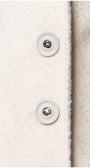 Close-up of a textured fabric surface with buttons on a light background Luna Fashion House