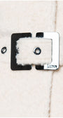 Close-up of a button on a textured fabric surface with 'LUNA' branding. Luna Fashion House