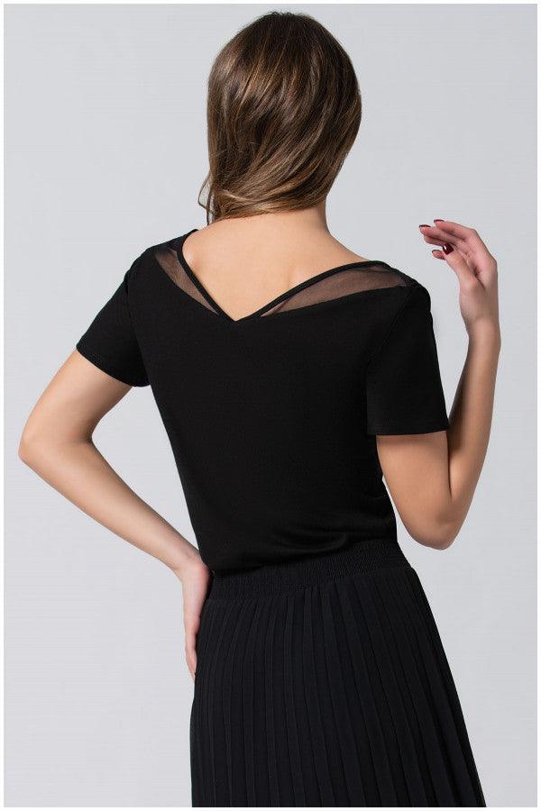 Back view of woman wearing black Lola business Top with pleated neckline and short sleeves paired with a black skirt