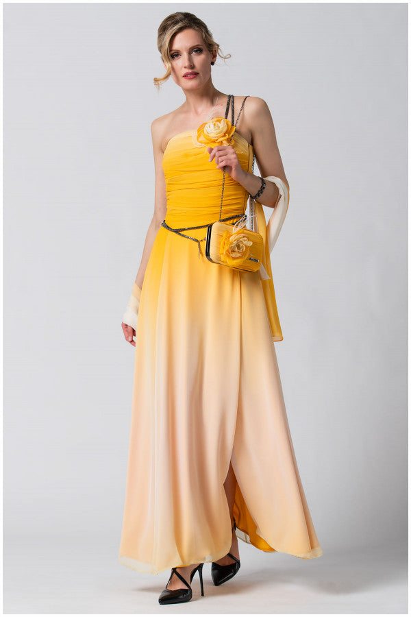 Woman in an yellow scarf and ombre yellow gown holding a matching purse and scarf with a floral detail, styled elegantly for evening wear.
