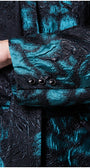 Close-up of a blue and black textured garment with buttons. Luna Fashion House design
