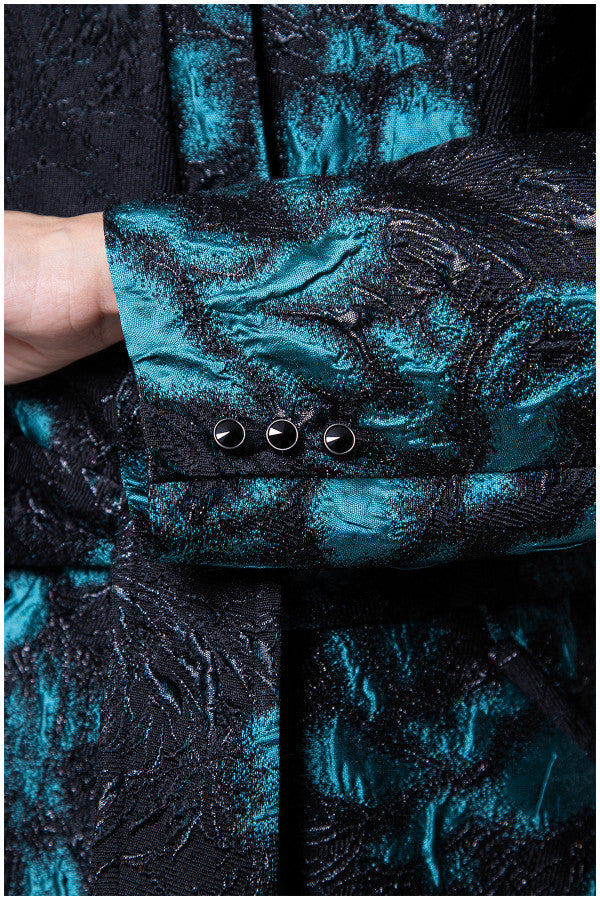 Close-up of a blue and black textured garment with buttons. Luna Fashion House design