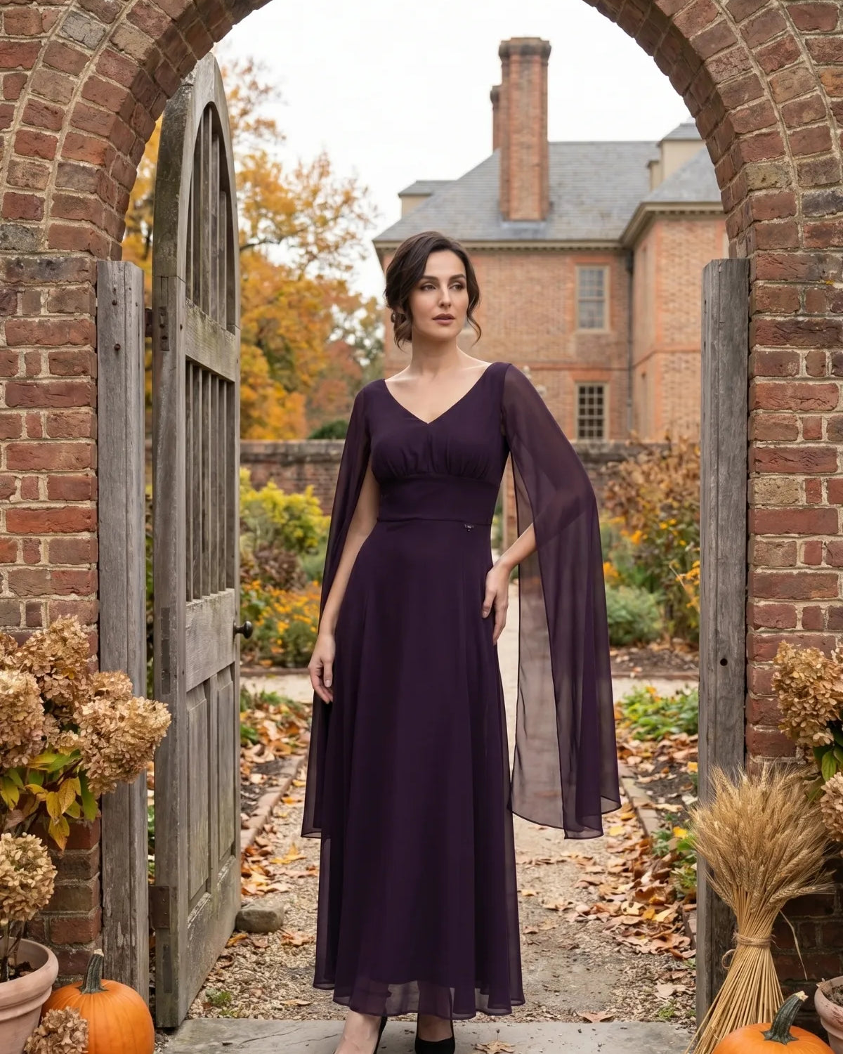 Plum long dress with sheer cape sleeves in an autumn garden