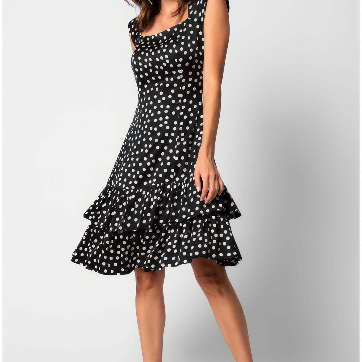 A woman wearing the Luna Betty Ruffle Dress In Black Polka Dot