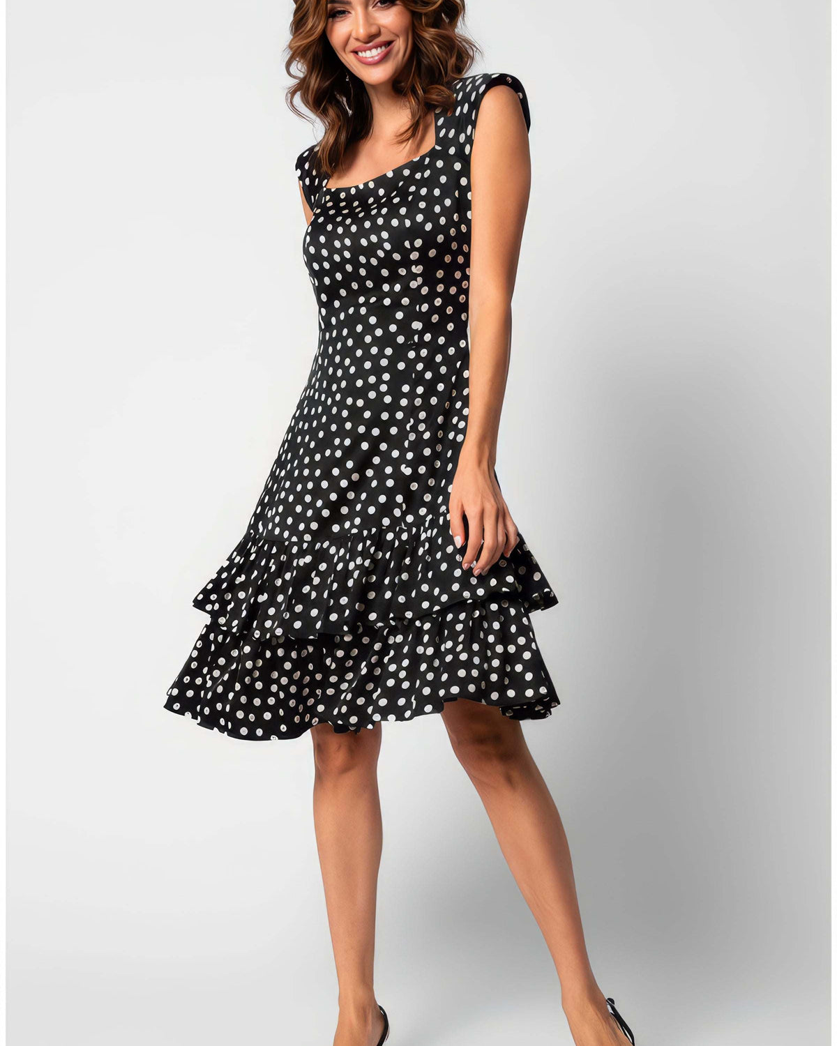 A woman wearing the Luna Betty Ruffle Dress In Black Polka Dot