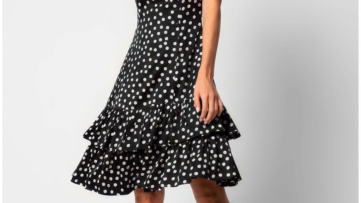A woman wearing the Luna Betty Ruffle Dress In Black Polka Dot