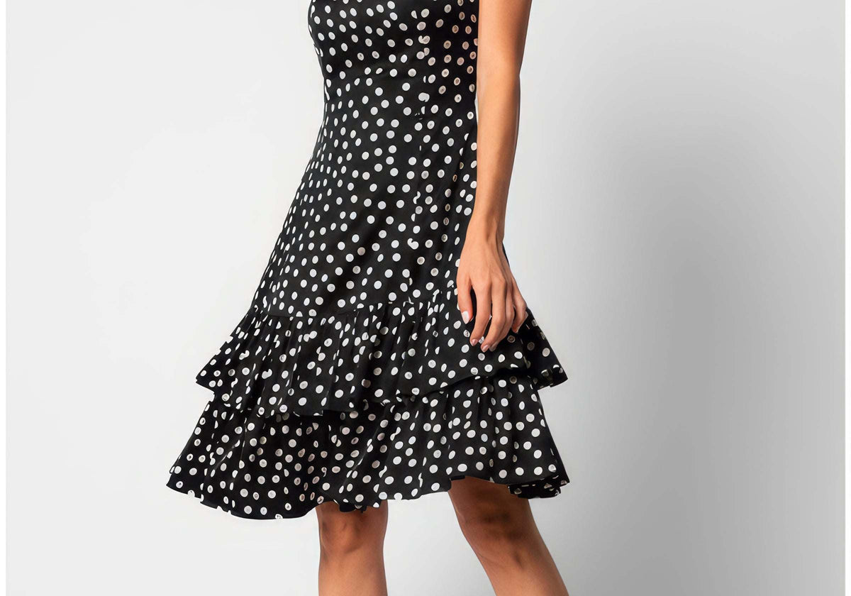 A woman wearing the Luna Betty Ruffle Dress In Black Polka Dot