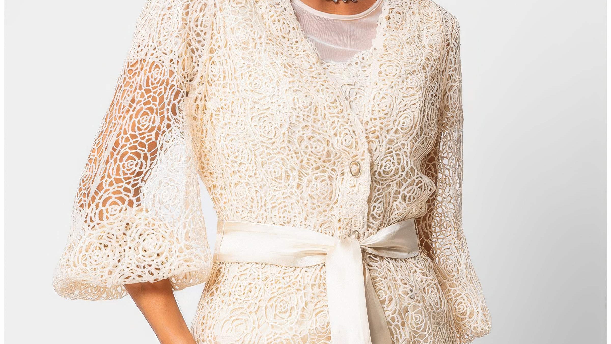 Ivory botanical fiber lace belted sweater with satin waist belt and draped silhouette on a white studio background