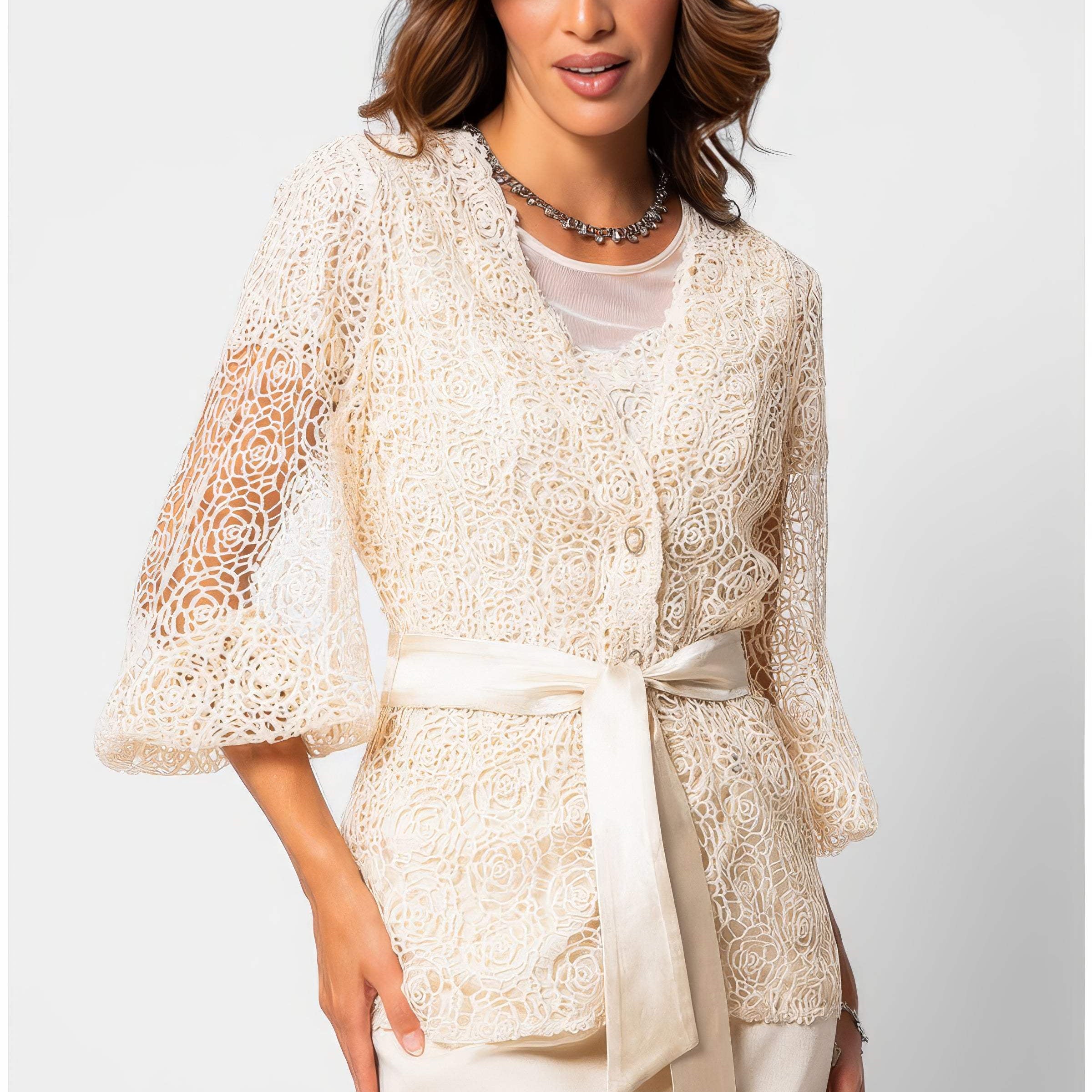 Ivory botanical fiber lace belted sweater with satin waist belt and draped silhouette on a white studio background