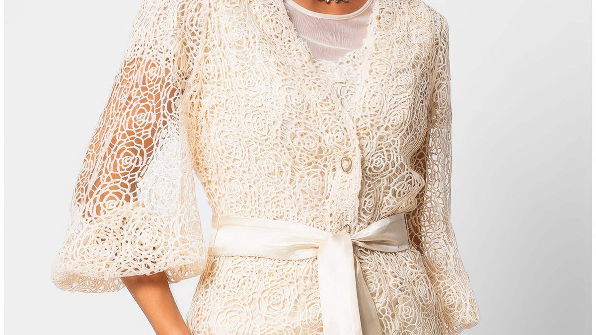 Ivory botanical fiber lace belted sweater with satin waist belt and draped silhouette on a white studio background