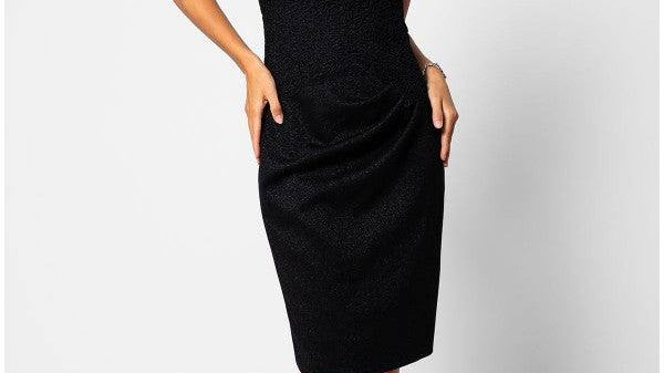 An elegant handmade black lace cocktail dress displayed against a neutral background, showcasing fine lace texture and tailored silhouette suitable for cocktail events
