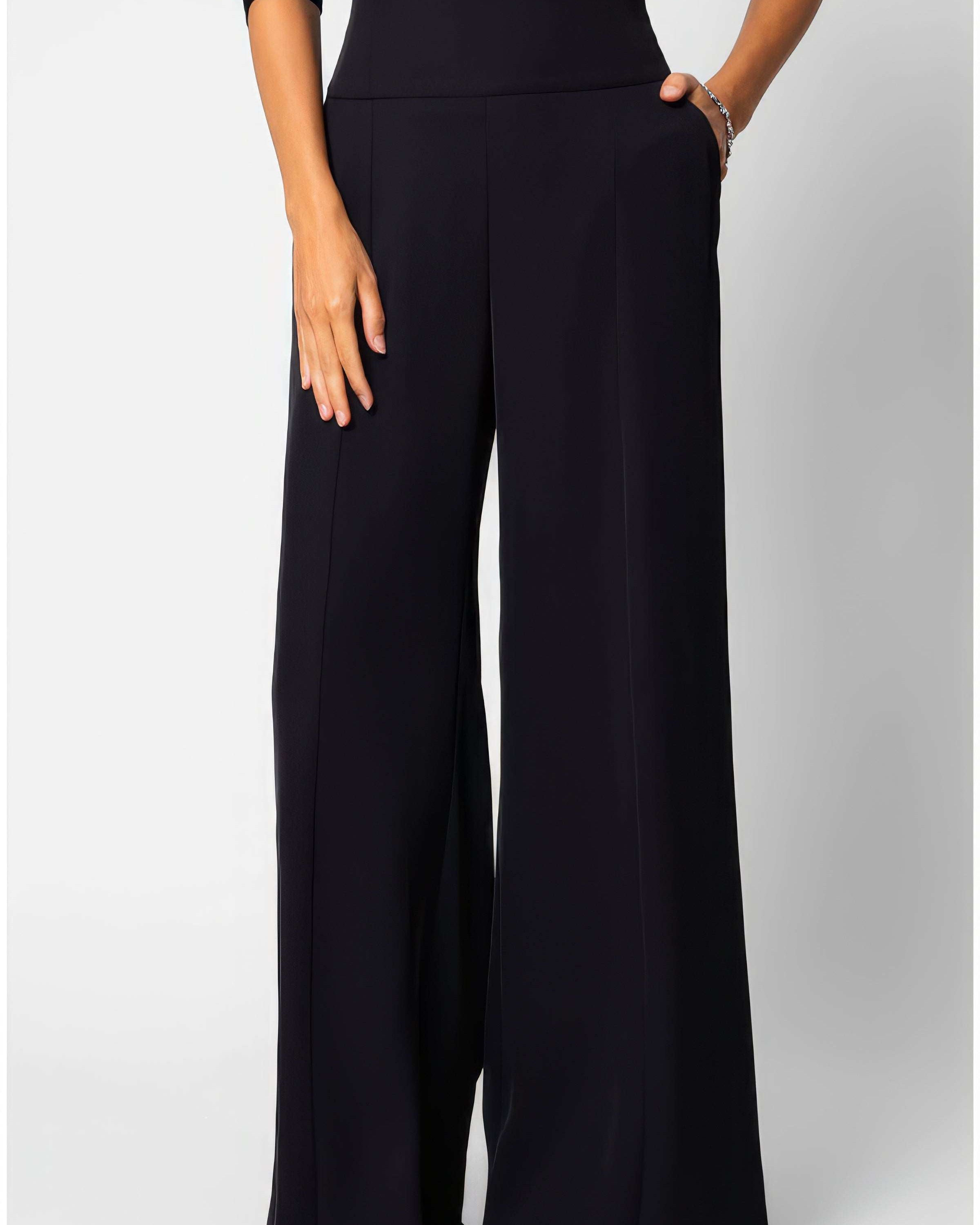 Black high-waisted wide-leg tailored trousers in fluid fabric with a clean natural waistline, front view on neutral background.