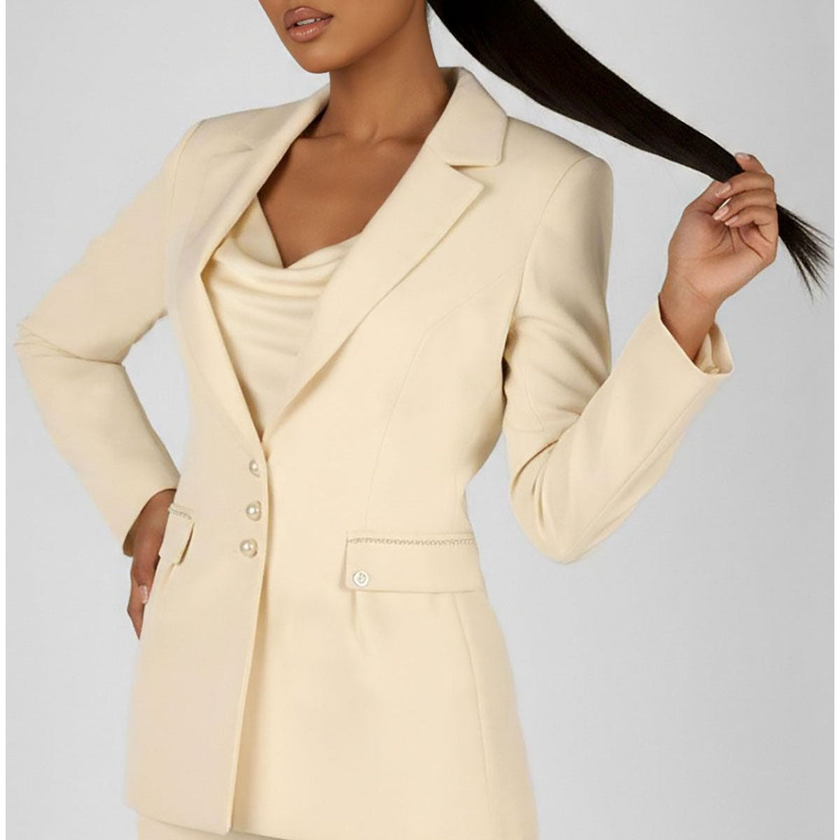 A selection of handmade Luna Fashion House occasion pieces including an ivory pearl detail blazer and navy sheath dress displayed in a European atelier setting