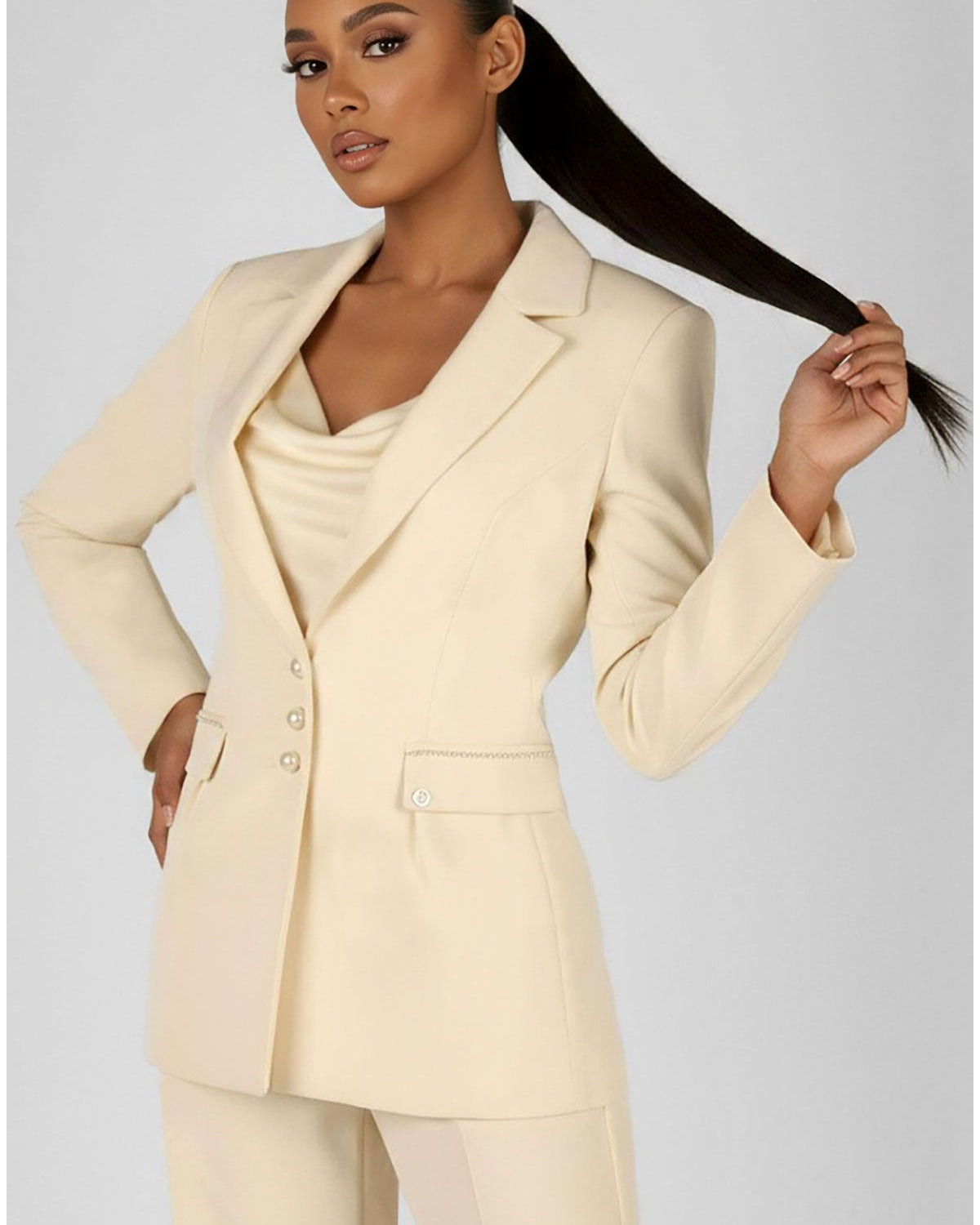 A selection of handmade Luna Fashion House occasion pieces including an ivory pearl detail blazer and navy sheath dress displayed in a European atelier setting
