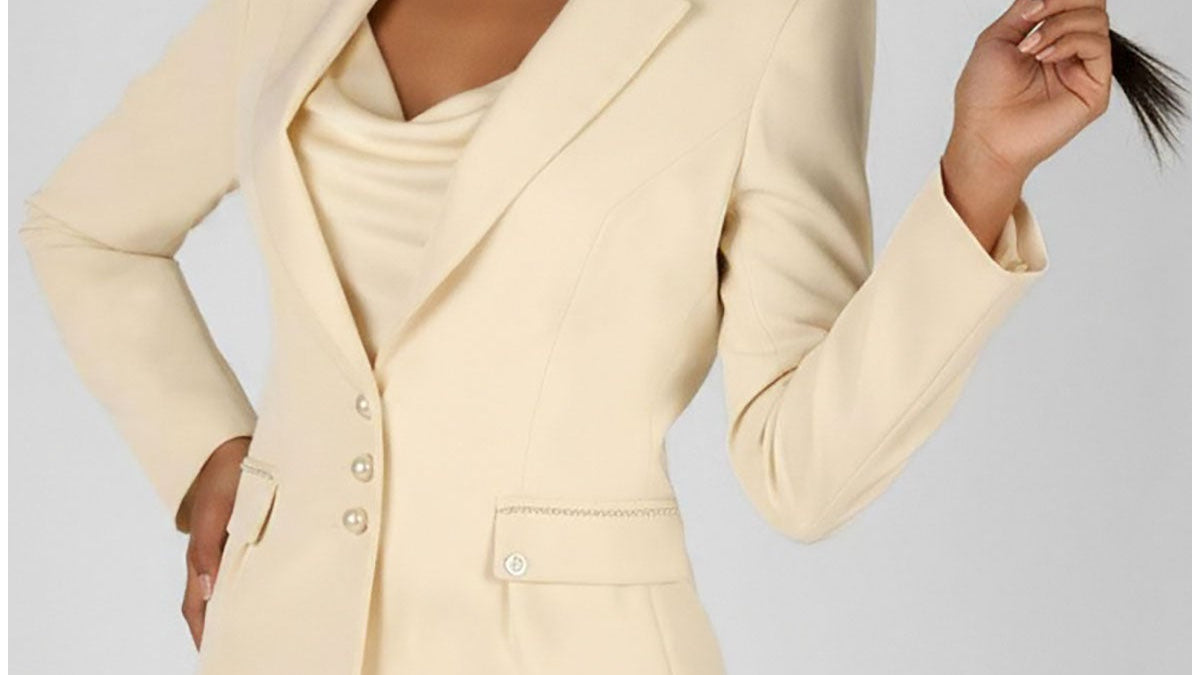 A selection of handmade Luna Fashion House occasion pieces including an ivory pearl detail blazer and navy sheath dress displayed in a European atelier setting