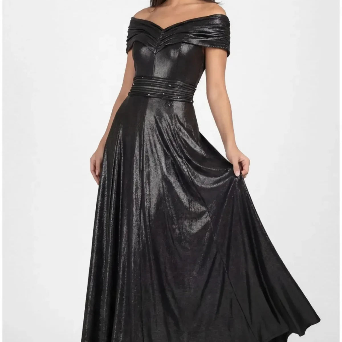 Floor-length anthracite metallic off-shoulder maxi gown with crystal-set waistband and flowing skirt on a tall figure