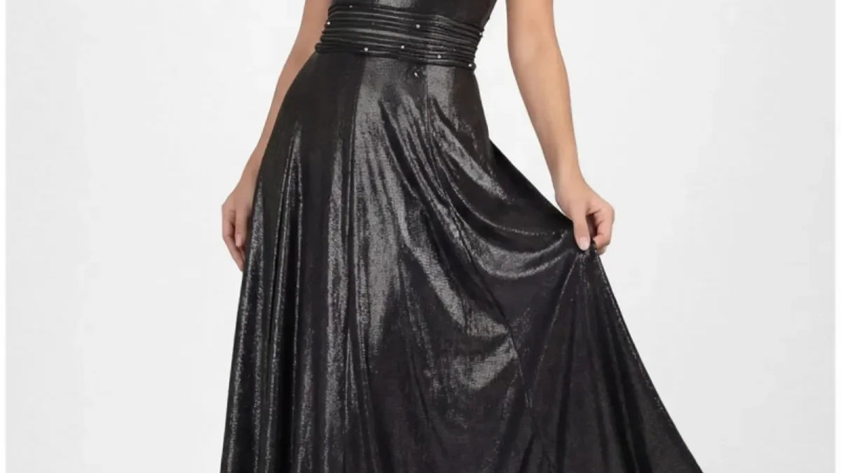 Floor-length anthracite metallic off-shoulder maxi gown with crystal-set waistband and flowing skirt on a tall figure