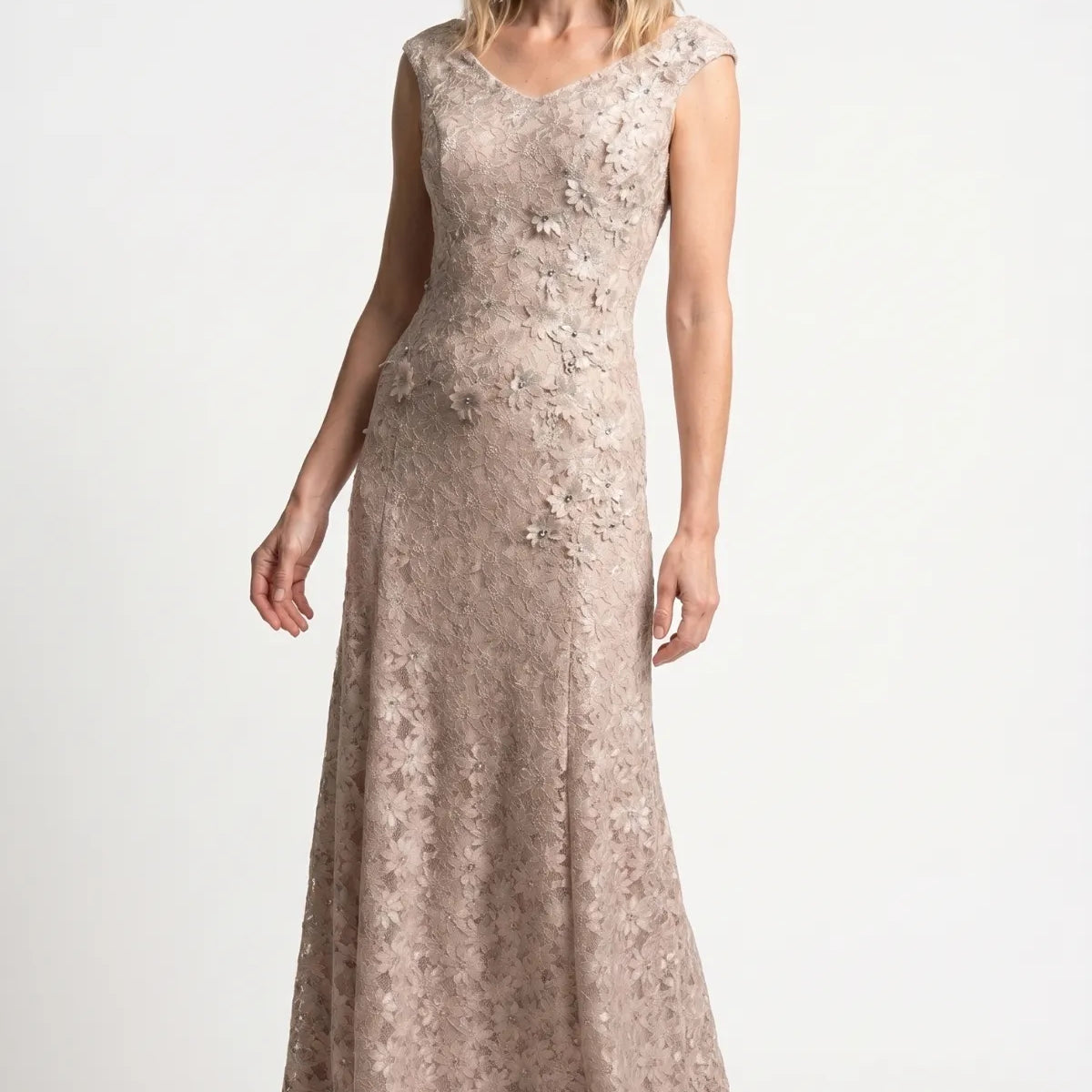 A selection of handmade Luna Fashion House occasion dresses including a beige lace maxi gown, a black lace cocktail dress, a green and black sequin maxi dress, and a gold short metallic dress arranged in an atelier setting
