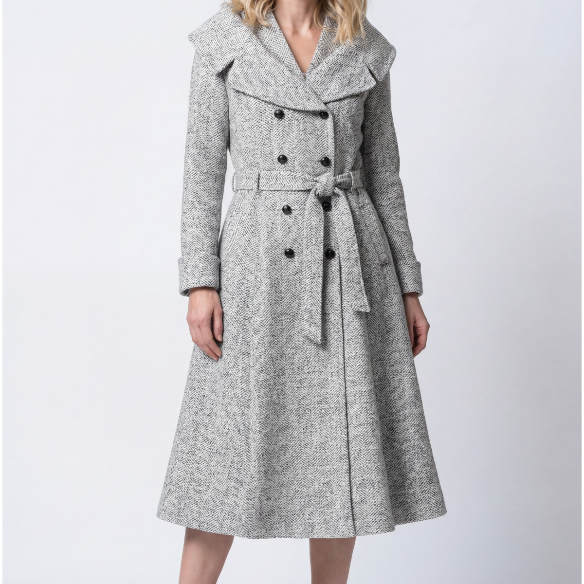 A selection of handmade Luna Fashion House occasion dresses and coats including the Nicole wool wrap coat in gray herringbone and the Emma teal floral jacquard light coat displayed in a European atelier setting