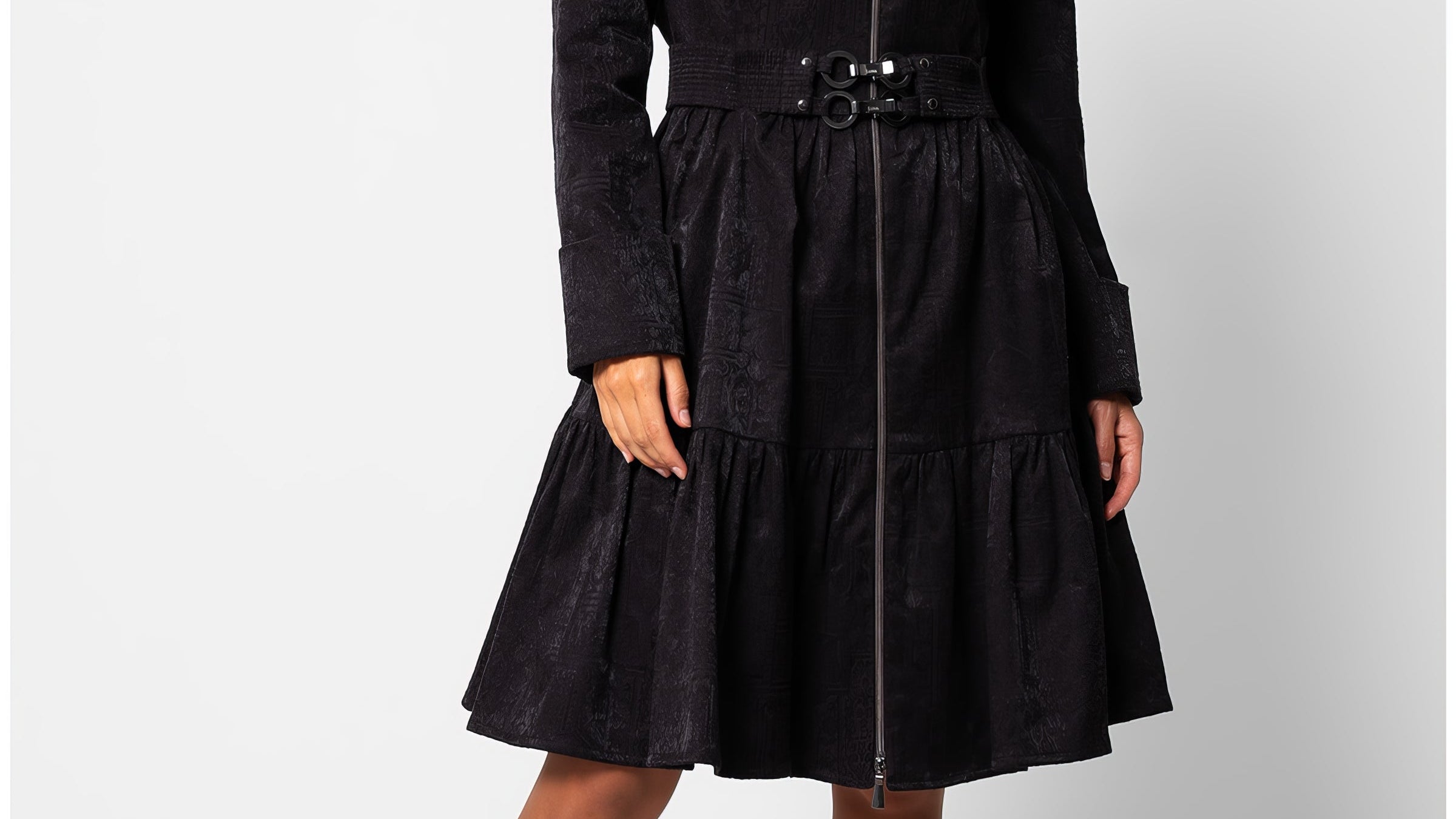 Black short tailored coat, Iris, in a cotton blend with a soft satin finish, wide stand collar, asymmetric zip, buckled belt, and a tiered skirt that ends above the knee