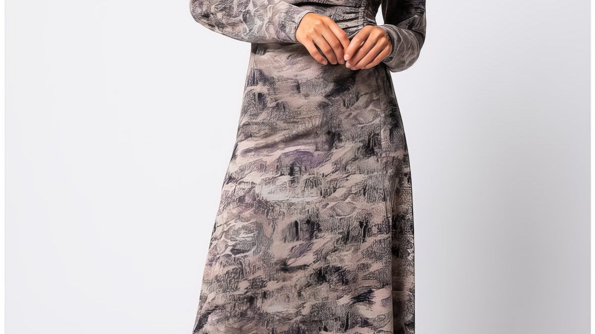 Model wearing the Brown Draped Midi Dress Mila in abstract taupe with ruched waist and long sleeves at a formal dinner setting