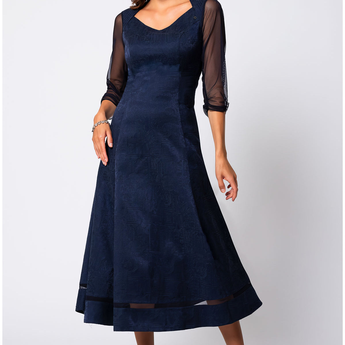 Navy jacquard midi dress with three-quarter sheer sleeves in a softly structured silhouette against a neutral studio background