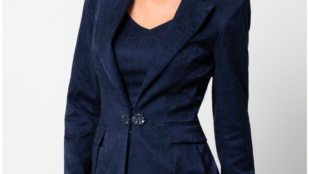 Navy tailored jacquard blazer with sculpted waist and decorative clasp closure, worn against a neutral background