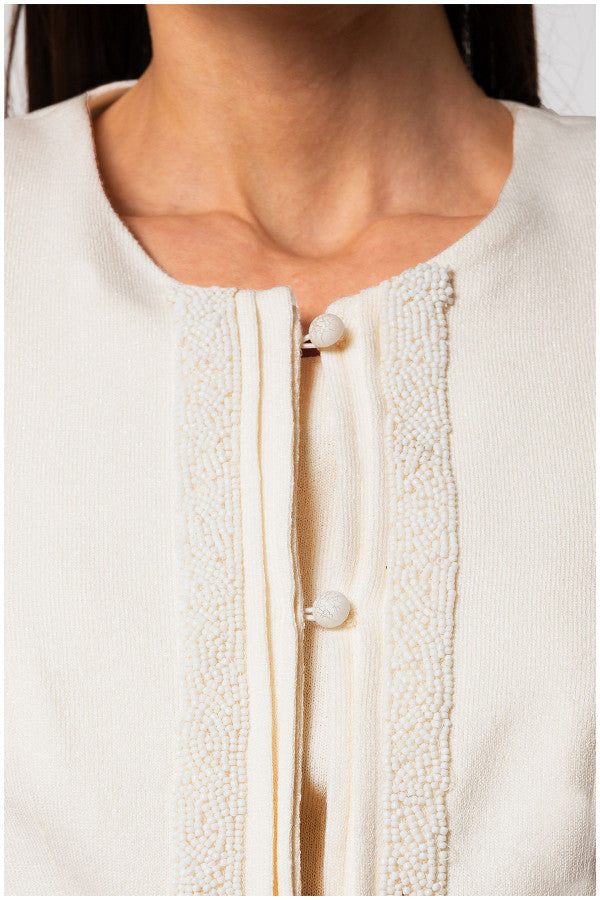Close-up of tailored blazer Jacket Lola in white showing round neckline and delicate beaded front button detailing.