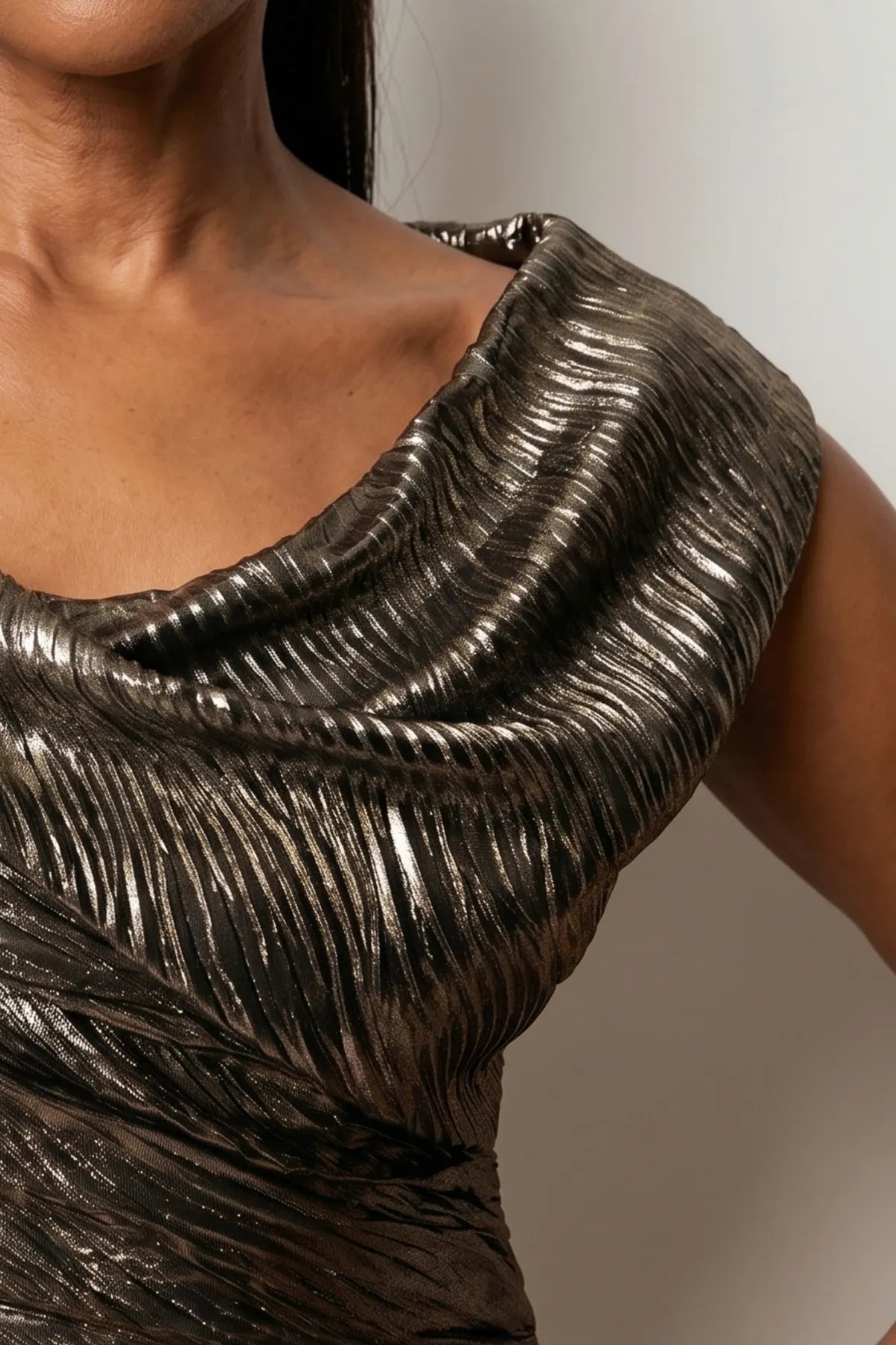 Close detail of the bronze metallic fabric and softly draped neckline showing the crinkled ruched surface