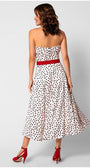 Back view of a strapless white elegant midi dress with black polka dots, red belt, and red high heel shoes