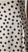 Close-up of white elegant midi dress satin fabric with black polka dots on the fitted waist section of the Melissa midi dress.