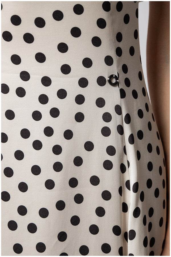 Close-up of white elegant midi dress satin fabric with black polka dots on the fitted waist section of the Melissa midi dress.